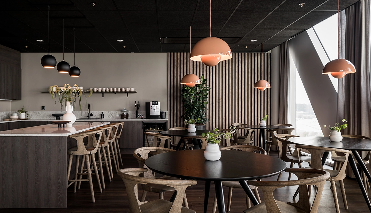 Personalkök och lunchrum med runda bord och pendellampor på WeAudits kontor i Göteborg
